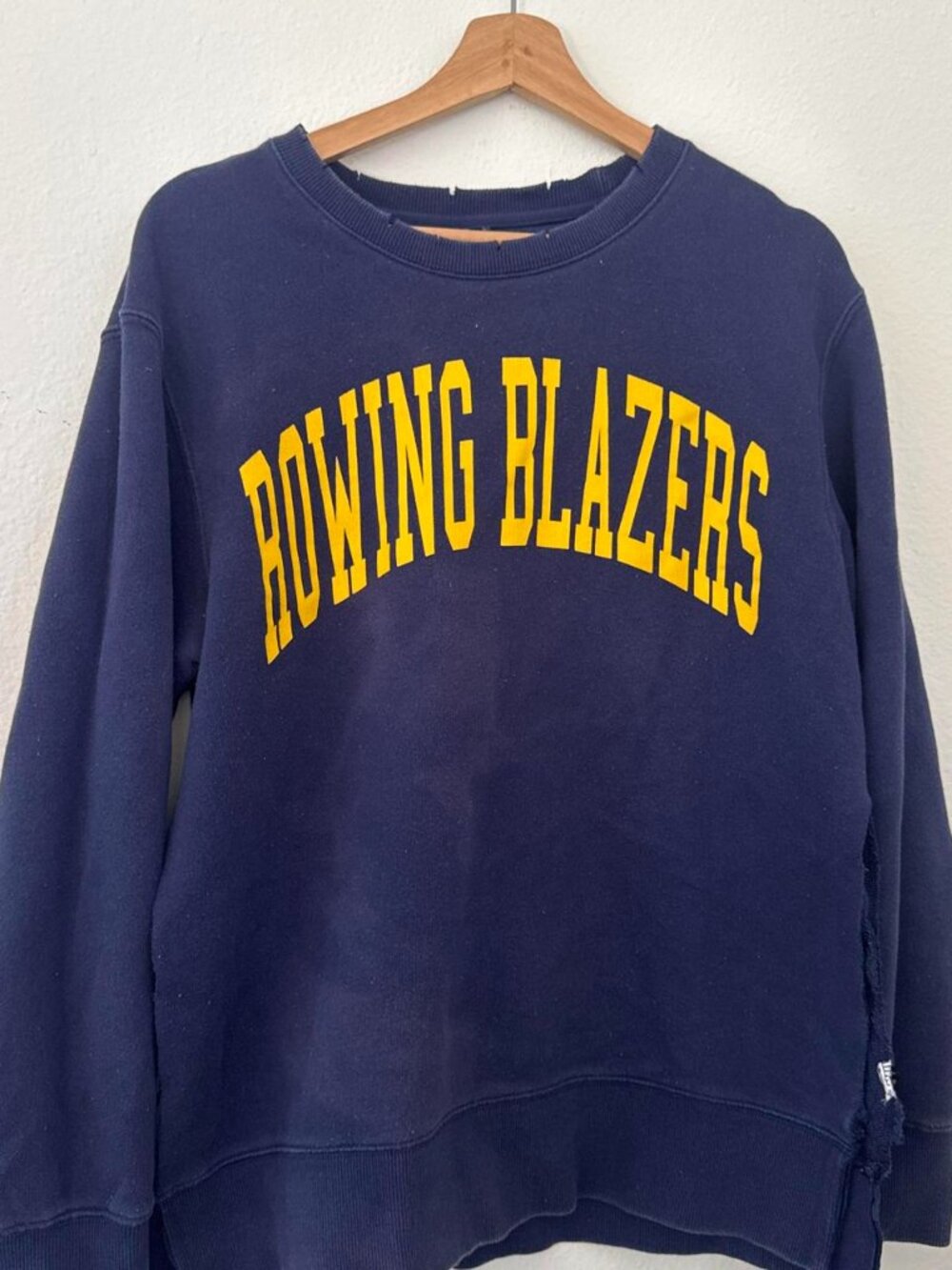 Rowing Blazers navy sweatshirt with yellow arched text reading 'ROWING BLAZERS'